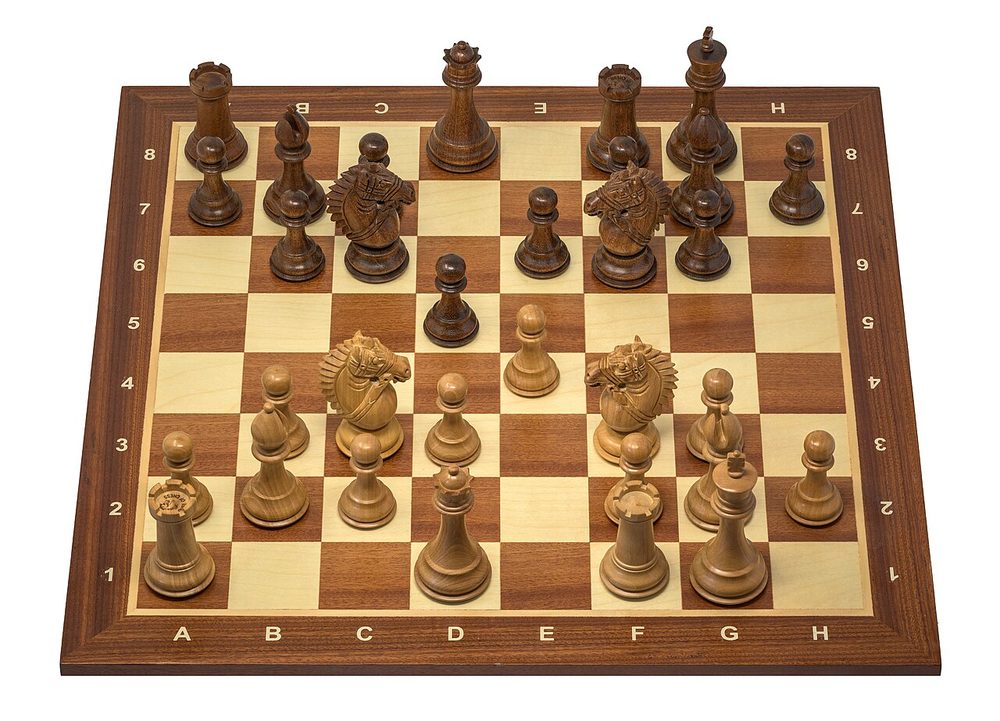 Wooden Staunton chess pieces set up on a board